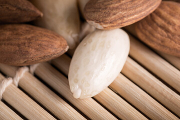 Several almonds on a wooden background with soft lighting, selective focus.