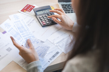 Business financial concept, owe asian young woman sitting stressed, hand calculate expense, cost or budget on table at home from invoice or bill have no money to pay mortgage or loan, debt bankruptcy.
