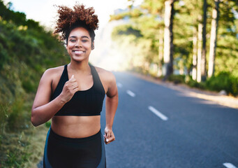 Fototapeta premium Happy woman, portrait and running with road for fitness, workout or outdoor exercise in nature. Active female person or young runner with smile on street for training, cardio or health and wellness
