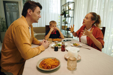 Family arguing during dinner with their son watching for their quarrel