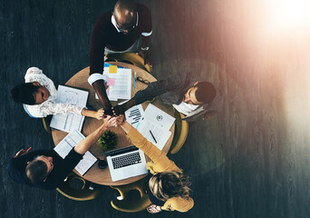 Above, business people and high five in circle, meeting or support for motivation, teamwork and diversity. Men, women and hands together in scrum by documents, technology or graphs at creative agency