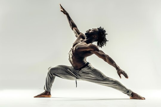 Shirtless male dancer strikes powerful, graceful pose demonstrating strength, flexibility. Poised in lunge, one arm reaching upward, other extending out