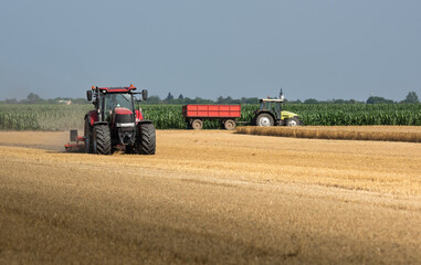 Tractor preparing land with seedbed cultivator.