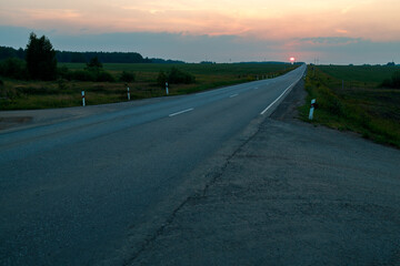 Fototapeta premium A long road with a sunset in the background