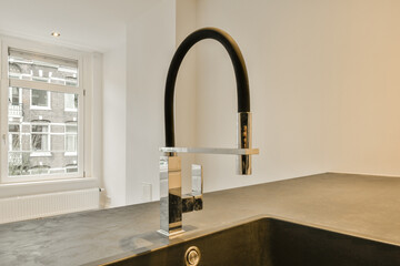 A kitchen with a black sink and a chrome f