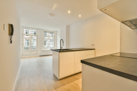 A kitchen with white cabinets and black counter tops and