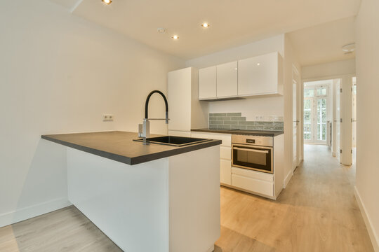A kitchen with white cabinets and a black counter top