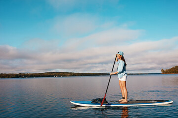 Woman, lake and smile for paddleboard on holiday with adventure, recreation and fun in Bali. Female person, happy and travel for summer vacation, journey and break to relax with fitness activity