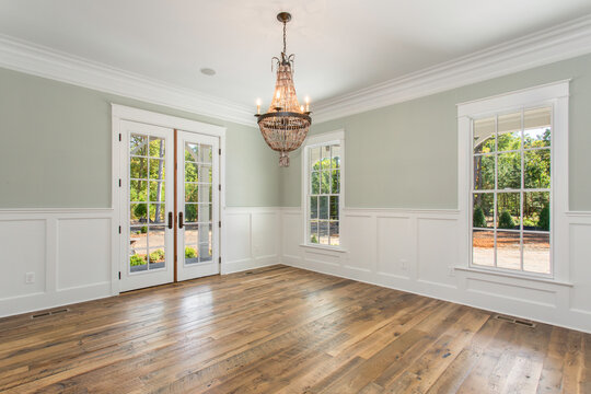 Bright Dining Room with Double Doors, Chandelier, and Natural Light Coming In