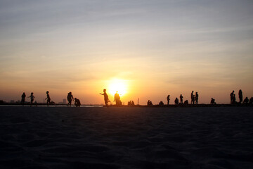 Sunset on the beach, Silhouettes of People on the Beach at Sunset