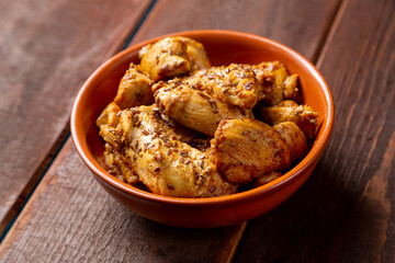chicken stewed in spices in a clay bowl on the table