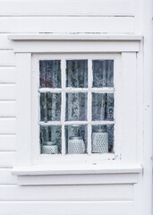 Traditional white painted wooden house window in Sogndalstrand. Charm and hospitality of South Norway.