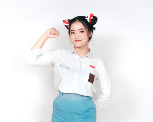 Attractive Indonesian female high school student showing strong gesture with raised arms and muscles smiling proudly isolated on white background.