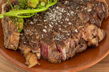 A wonderful grilled beef ribeye with a side of French fries and roasted green peppers