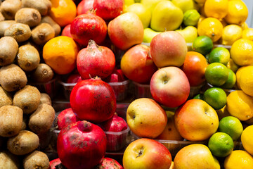 Apple, kiwi, orange, garnet, lemon on open market. Healthy and food concept. Tropical fruits display at a farmers market