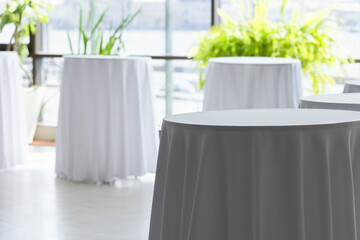 Round tables for the buffet are covered with white tablecloths
