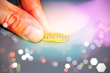 Fentanyl pill, conceptual image with light effect to illustrate the drug addiction