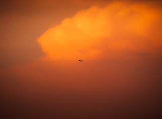 Aeronave sobrevolando el cielo del atardecer delante de una nube gigante