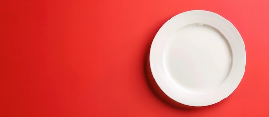 Empty white plate on tablecloth on colored background with space for your design.