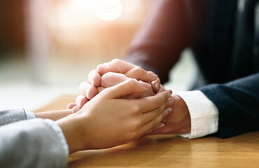Business people, hands together and support with comfort for care, grief or trust on office desk....
