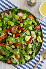 Homemade Crispy Chicken Salad with Tomato and Cucumber on a Plate, top view.