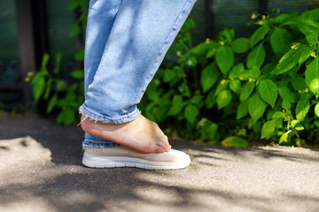 woman's legs in one shoe standing on one foot, symbolizing balance, grace, and individuality in...