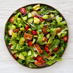 Homemade Crispy Chicken Salad with Tomato and Cucumber on a Plate, top view.