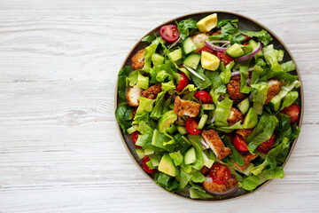 Homemade Crispy Chicken Salad with Tomato and Cucumber on a Plate, top view. Copy space.