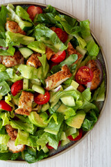 Homemade Crispy Chicken Salad with Tomato and Cucumber on a Plate, top view.