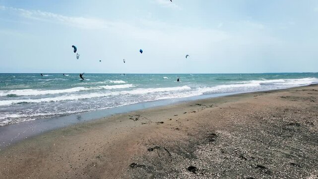 People surf with Kyte surfers on the sea waves in summer near people bathing. Extreme sports and outdoor life. Warm holiday with wind on the sea High speed and adrenaline. Strong wind