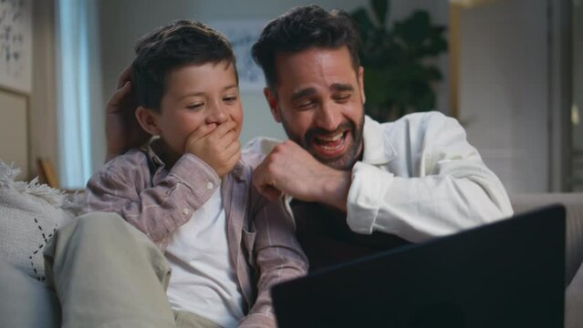 Boy man enjoying amusing tv show watching laptop closeup. Laughing father son