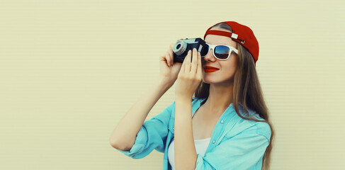 Portrait of happy young woman photographer with film camera, modern girl taking a picture