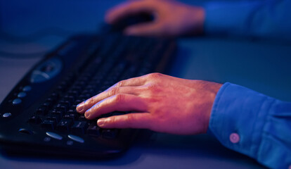 A close-up photograph captures a hand typing on a black keyboard, with the fingers hovering over...