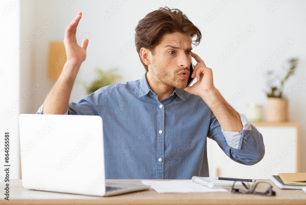 Poster a man sits at a desk, working on a laptop and talking on his phone. he looks frustrated and appears 