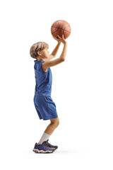 Full lenggth profile shot of a boy shooting a basketball