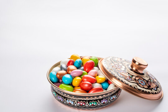 Colorful almond candies in the stylish,crystal candy bowl on white with copy space.The Sugar Feast concept. (Turkish name; Ramadan - Ramazan bayrami, Seker bayrami)