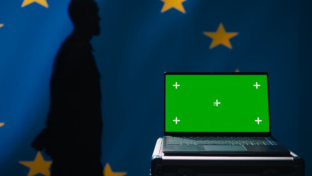 European Union agency using green screen laptop to protect against mass propaganda affecting elections. EU security service engaging in psychological operations using mockup device, close up, camera B - Powered by Adobe