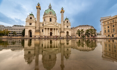 Obraz premium Vienna, Austria, August 18, 2022. Beautiful daytime shot with the Church of San Carlo Borromeo reflected in the fountain in front. Travel destinations.