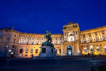 Fototapeta premium Vienna, Austria, August 18, 2022. The Hofburg Imperial Palace at blue hour. The illumination enhances the impressive facade.