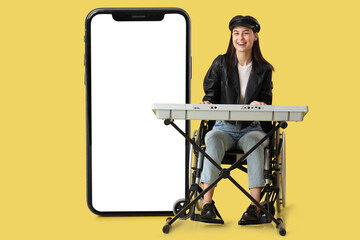 Female artist in wheelchair playing synthesizer on yellow background
