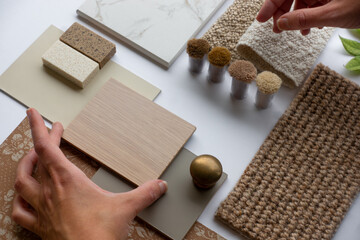 Hands of Interior Designer and Architect with Material Sample Board with Fabrics, Carrara Marble,...