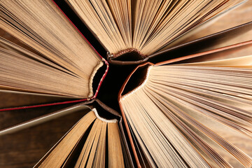 Open old books on wooden background, closeup