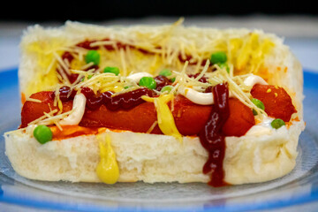 Traditional Brazilian style hot dog with sausage, peas and straw potatoes