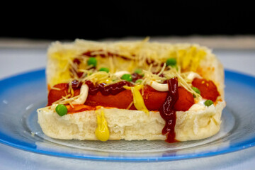 Traditional Brazilian style hot dog with sausage, peas and straw potatoes