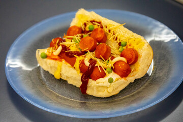 Traditional Brazilian style hot dog with sausage, peas and straw potatoes