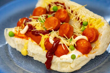 Traditional Brazilian style hot dog with sausage, peas and straw potatoes