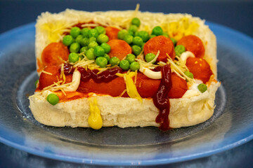 Traditional Brazilian style hot dog with sausage, peas and straw potatoes