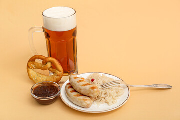 Plate with tasty Bavarian sausages, sauce, sauerkraut, pretzel and mug of beer on beige background. Oktoberfest celebration
