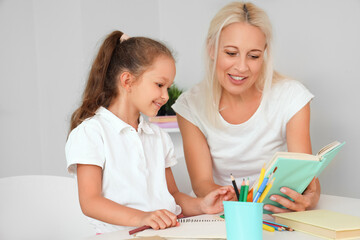 Little girl with her grandmother studying at home