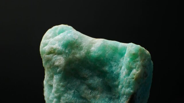 Amazonite ((K,Na)AlSi3O8) Mineral. Source (ore) of Rubidium and Cesium. Vibrant green to blue-green hues and smooth texture. Significance in gemology. Close-up smooth rotaion. Green variety